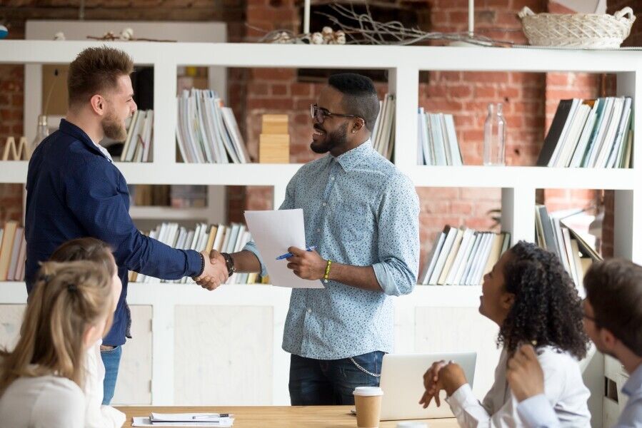 Two people shaking hands at a meeting